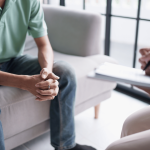 Médico com paciente fazendo perguntas para identificar possíveis riscos psicossociais