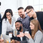 7 pessoas juntas em um ambiente de trabalho. Em frente ao computador fazendo um planejamento estratégico.